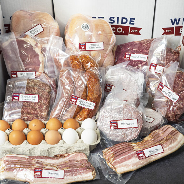 Assorted packaged meats and eggs arranged in front of branded boxes.
