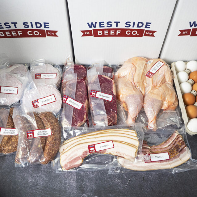 Assorted packaged meats and eggs, including burgers, sausages, sirloin, whole chicken, bacon, and a carton of eggs, arranged in branded boxes.