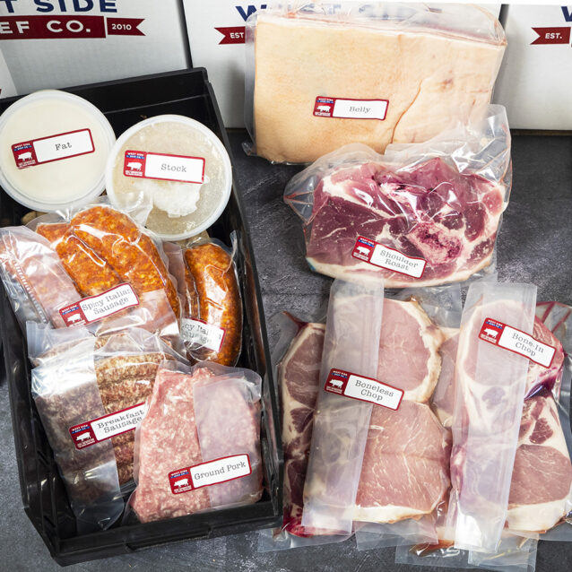 Assorted packaged pork products, including pork belly, shoulder roast, chops, sausages, ground pork, lard, and stock, arranged in branded boxes and trays.