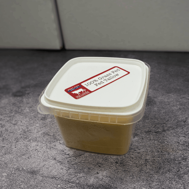 Container of beef tallow with labeled lid on a countertop.