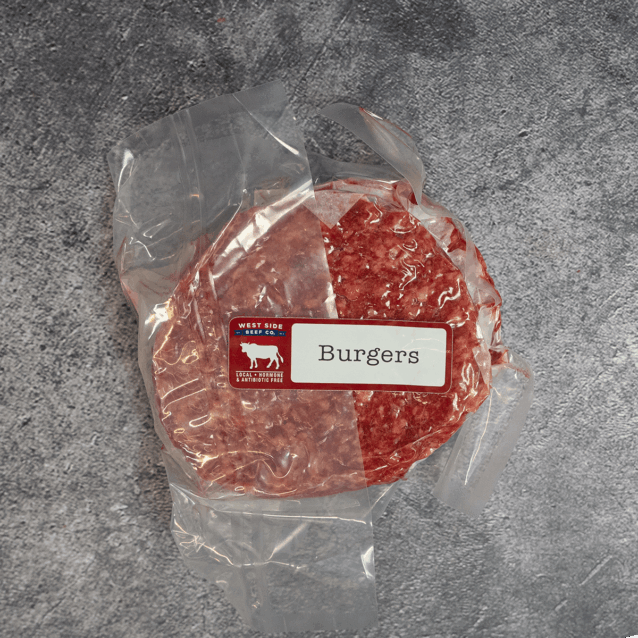 Stack of beef burger patties vacuum-sealed in clear packaging with label.