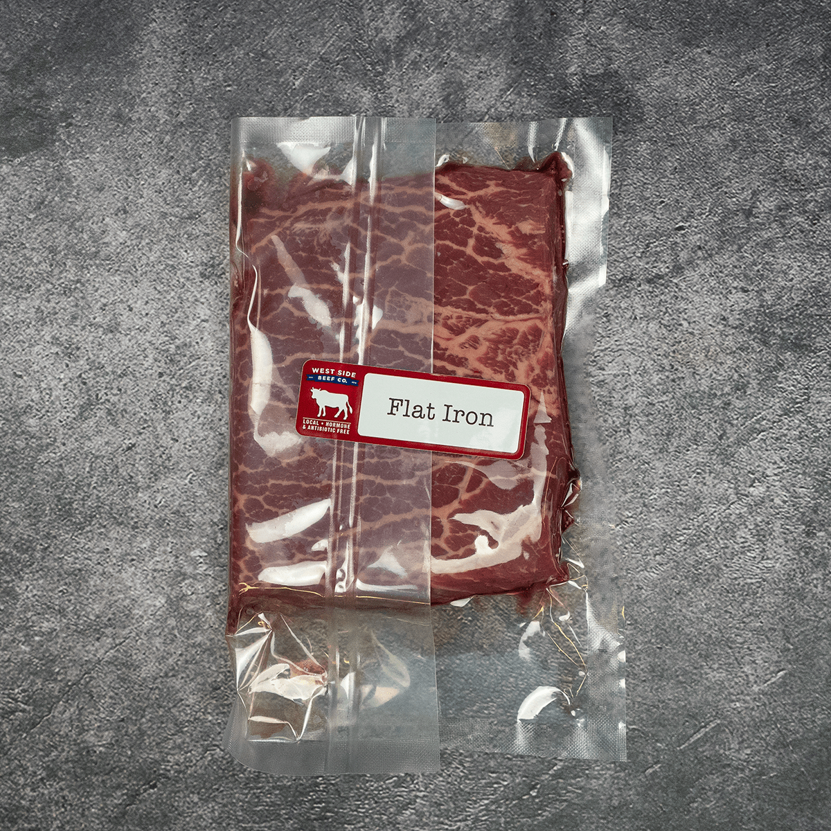 Flat iron steak vacuum-sealed in clear packaging with label.