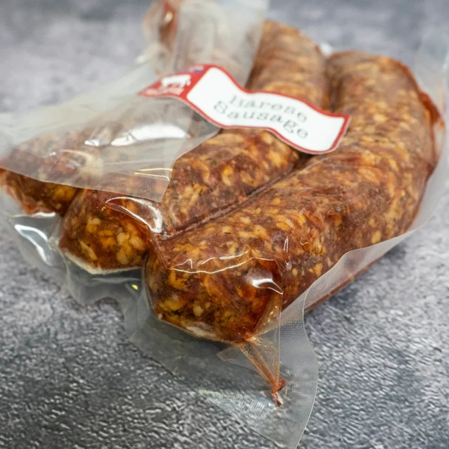 Close-up of vacuum-sealed Barese sausages from West Side Beef Co. showing detailed texture and seasoning.