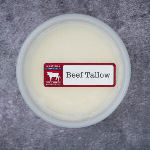 Beef tallow in a sealed plastic container on a textured surface.