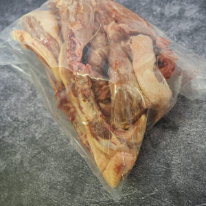 Bag of chicken bones on a gray textured surface.