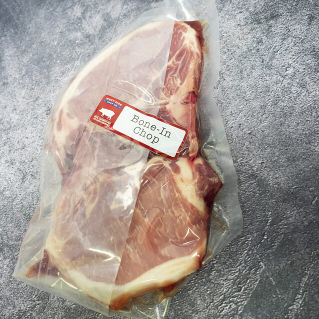 Vacuum-sealed bone-in pork loin chops with a "Bone-In Chop" label on a gray textured surface.