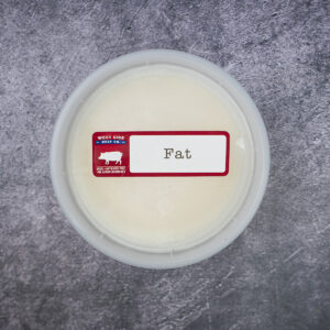 Round plastic container of pork lard with a "Fat" label on a gray textured surface.
