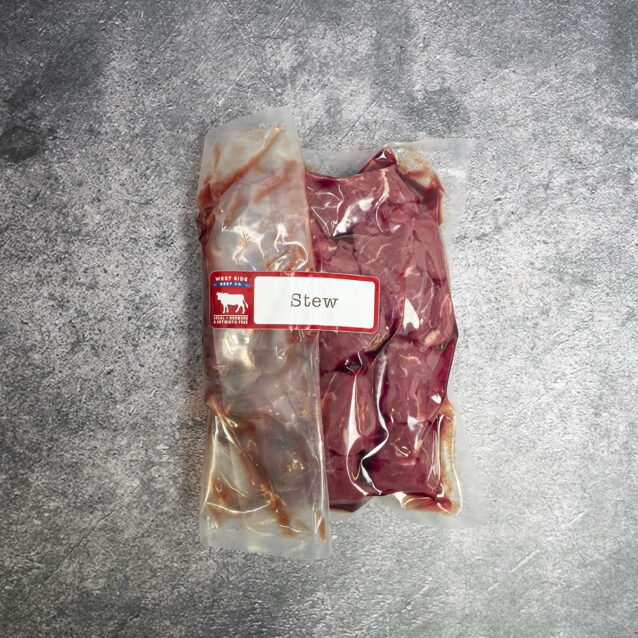 Vacuum-sealed package of cubed beef stew meat, labeled and placed on a gray surface.