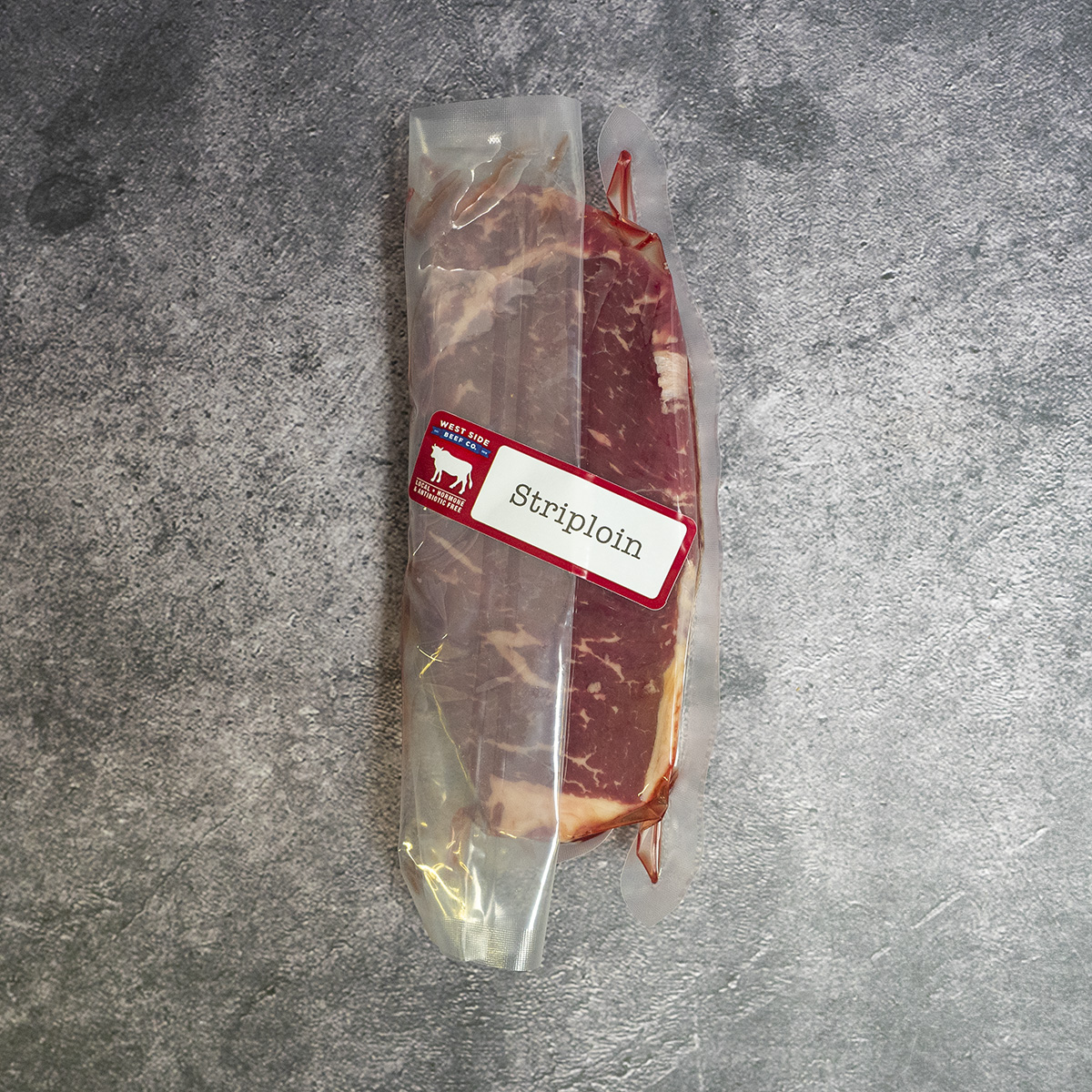Dry-aged thick-cut striploin steak (~22 oz), vacuum-sealed.