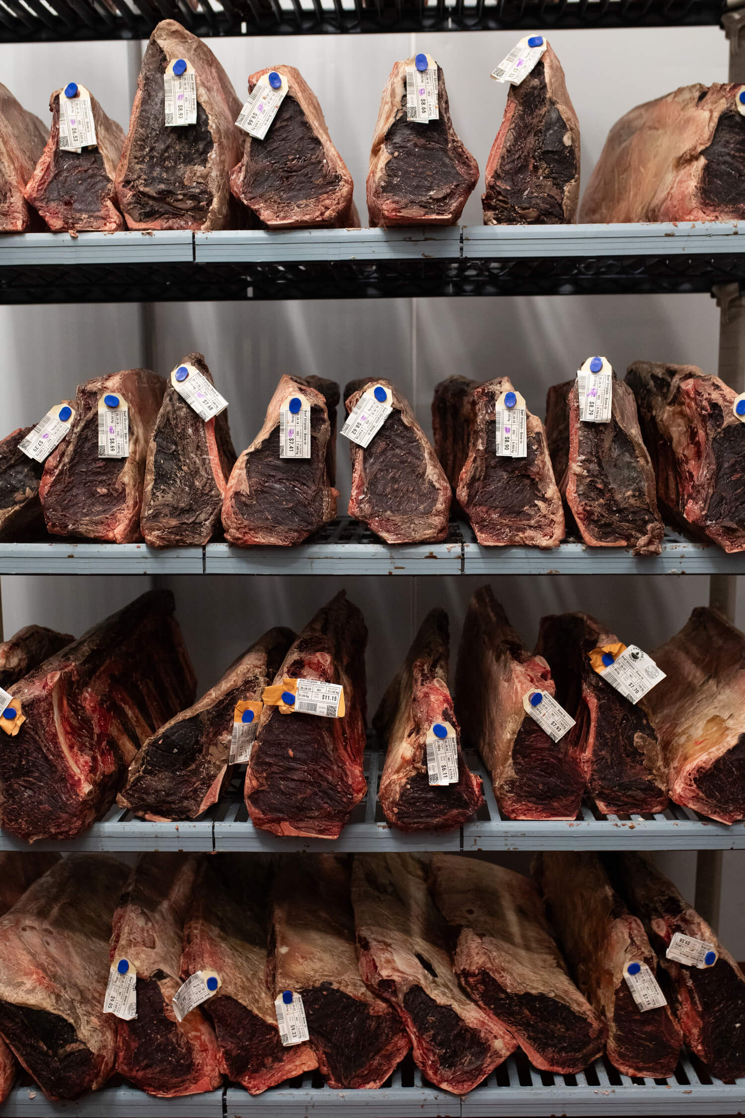 Rows of meat cuts with labels arranged on shelving.