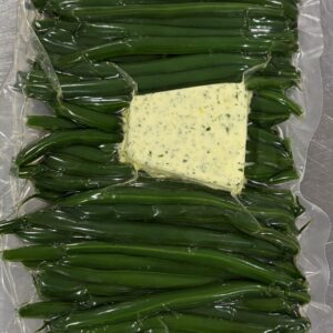 green beans in a vac bag with a compound butter on top