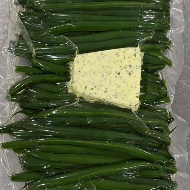 green beans in a vac bag with a compound butter on top